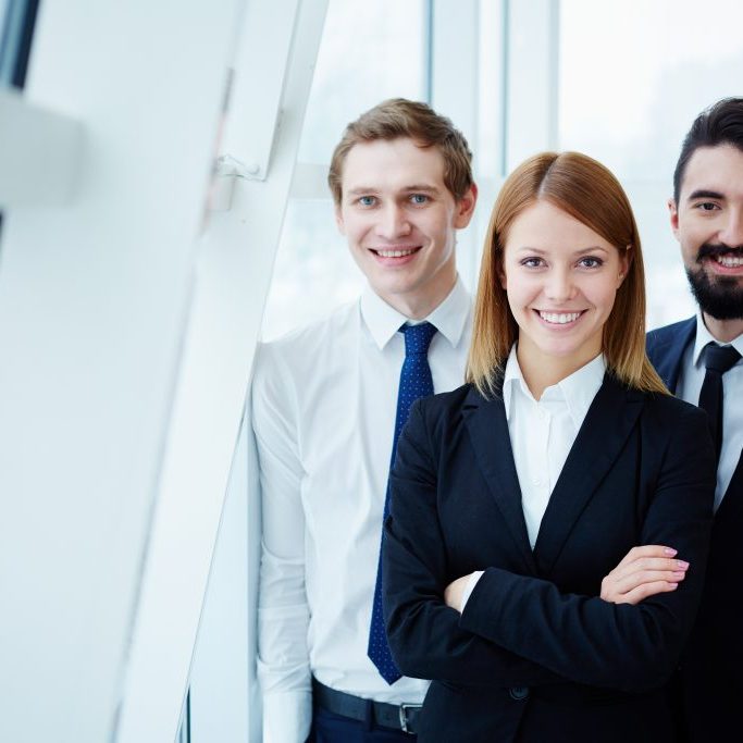 Business team Three successful business partners looking at camera with smiles